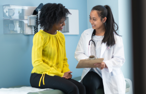 A doctor speaks to her female patient in an office