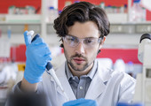 A young male researcher using a pipette in a laboratory.