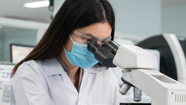 Female scientist looking into a microscope