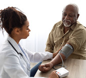 A man getting his blood pressure checked by a female healthcare provider