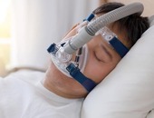 Boy sleeping in a hospital bed with an oxygen tube under his nose