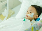 Boy sleeping in a hospital bed with an oxygen tube under his nose