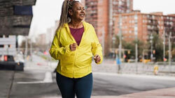 Older woman smiling while walking outdoors.