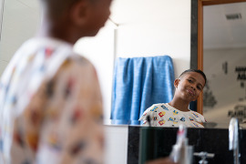 Young boy looking at himself in the mirror