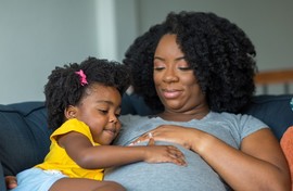 Mother and child hugging on couch