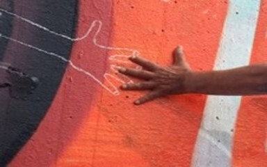 Hand touching chalk outline of hand.