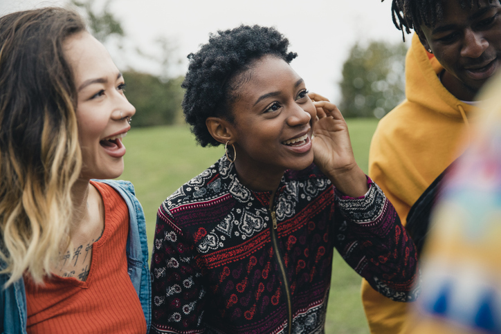 Group of teens standing talking to one another.