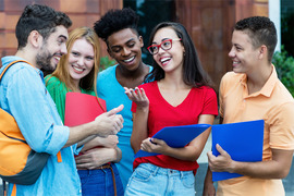 Diverse group of teens standing together talking.