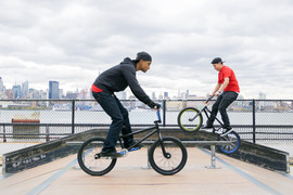 Two teenage boys riding their bikes in a skatepark.
