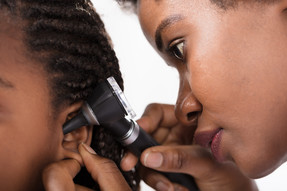 doctor checking child's ear with otoscope