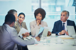 A group of business people talking around a table.