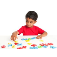 A young boy playing with alphabet letter toys.