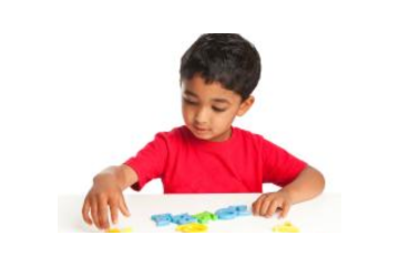 A young boy playing with alphabet letter toys.
