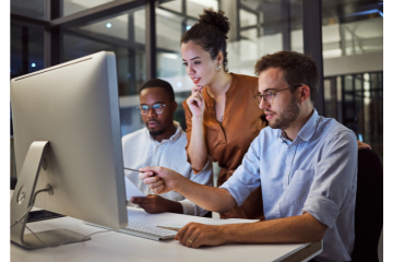 Three professionals viewing a computer screen.