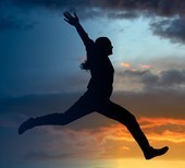 Person leaping with sunlight backdrop