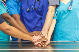 Multiracial team of doctors placing hands on top of each other