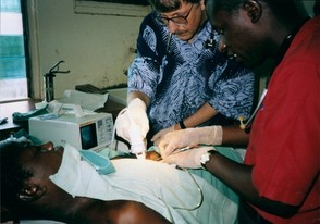 Dr. Francis S. Collins examining an African patient with another health professional