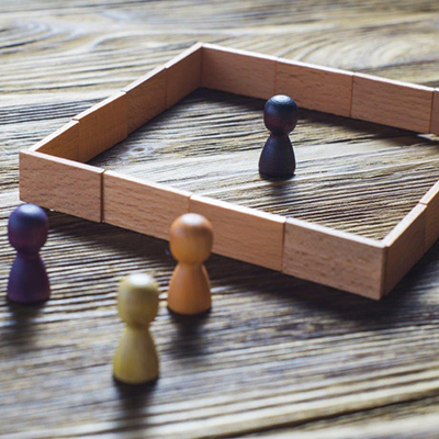 Stock image of colored peg inside a square and outside pegs, depicting structural racism