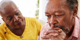 Senior woman comforting man with depression at home