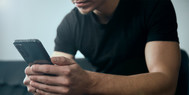 man looking down at phone screen
