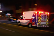Ambulance speeding through traffic at nighttime