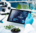 Scientist with plants and a tablet