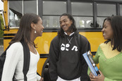 Teens standing near a school bus