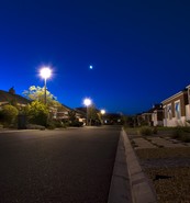 Image of a street at night with streetlamps lit 
