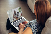 Close up of young woman using a lap top to get online medical help during videocall with a doctor.