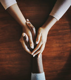 Hands holding across a table.