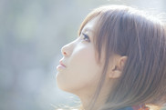 A young woman stares pensively upward