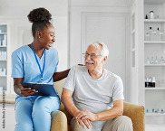 A health care aide assists an older patient.