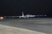 A small aircraft (NASA's ER-2) takes off from a runway at night.