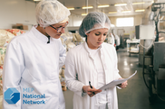 two female workers looking at a report in a manufacturing facility