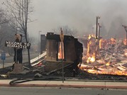 A welcome sign stands next to burned buildings in Paradise after the Camp Fire. 