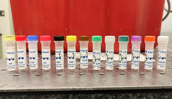 A row of plastic vials with different-colored caps all labeled "Glycan."