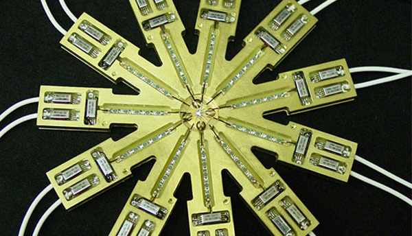 Voltage divider is a gold-colored circular device with 11 spokes leading to two wires each.