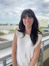 Ashley Boggs poses for a picture on an outdoor balcony. 