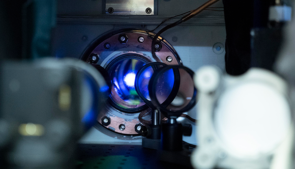 A small bright area appears within the circular opening of an atomic clock. 