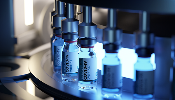 Vials of COVID-19 vaccine are lined up on a manufacturing machine.