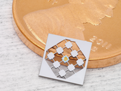 Small diamond shaped device next to a penny