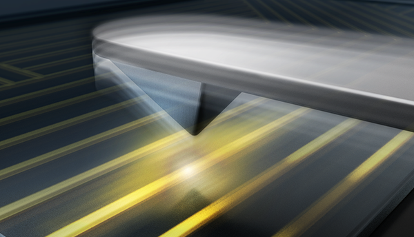 Illustration shows the cantilevered tip of an atomic force microscope over glowing parallel wires. 