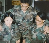 Casual snapshot shows four young people in Army uniforms clowning around for the camera.
