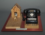 Wooden
                                          house next to an old rotary
                                          dial telephone