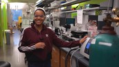 Lynnora Grant stands next to a lab counter crowded with scientific equipment.