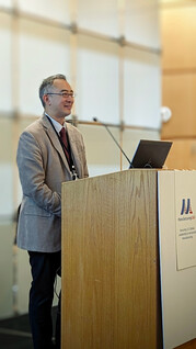 Photo of Dr. Eric Lin at a podium