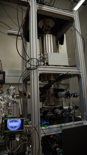 NIST-F3 fountain clock is a large piece of scientific equipment surrounded by a metal frame with a small monitor to the left. 