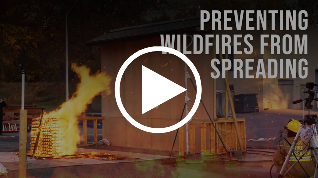 Title screen from video shows flames on a test structure and reads "Preventing Wildfires From Spreading."
