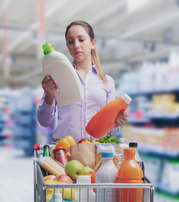 Consumer examining bottle labels in grocery store 