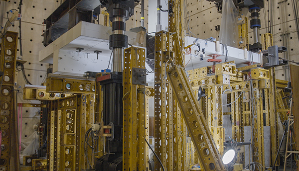 Horizontal concrete slab for Champlain testing is visible in a forest of scaffolding and equipment in a large indoor space. 